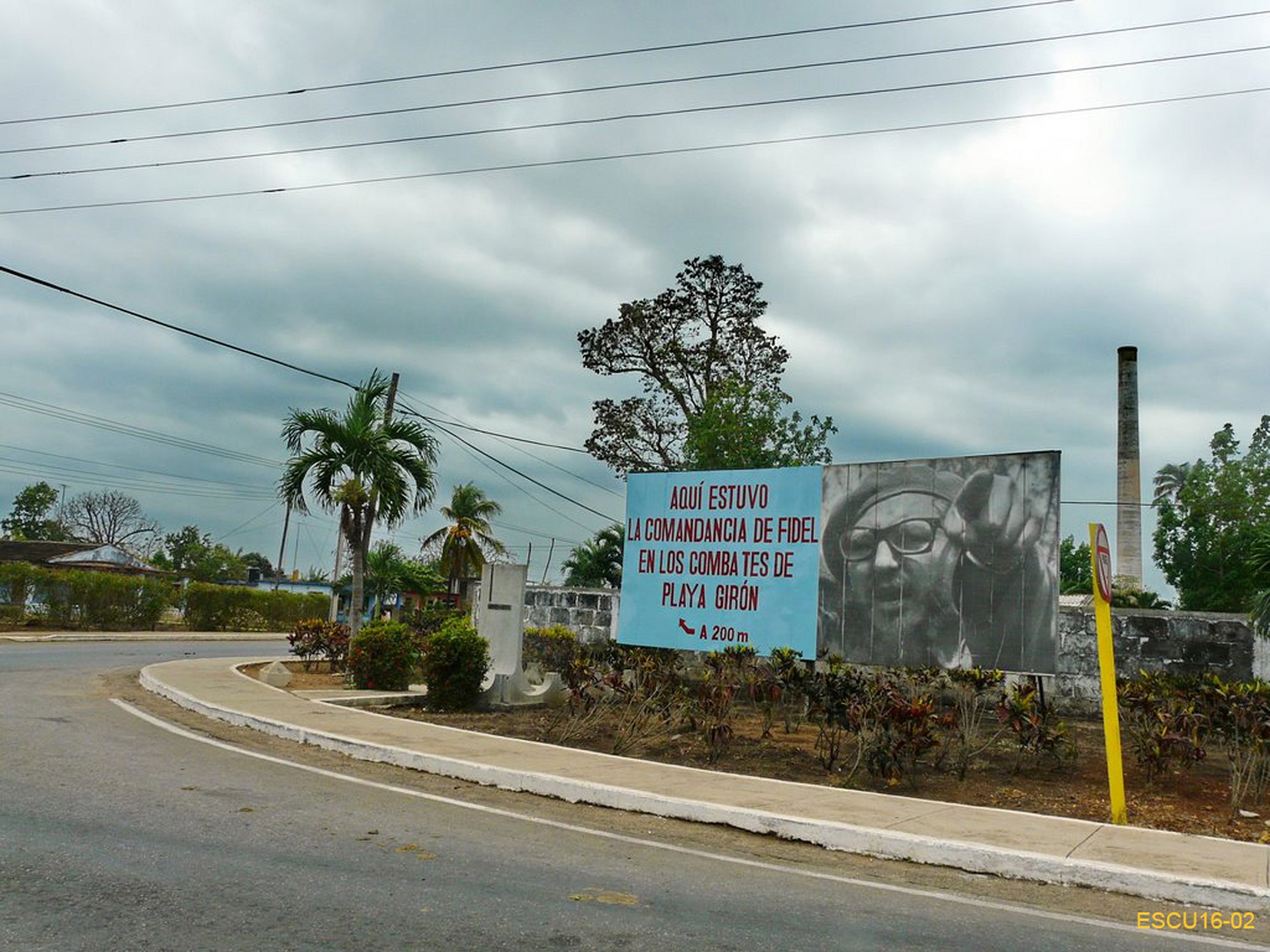 02 - Siamo sulla curva che dalla periferia di Jaguey Grande immette sulla carrabile 116. Dietro il cartellone si nota la ciminiera dello zuccherificio Central Australia